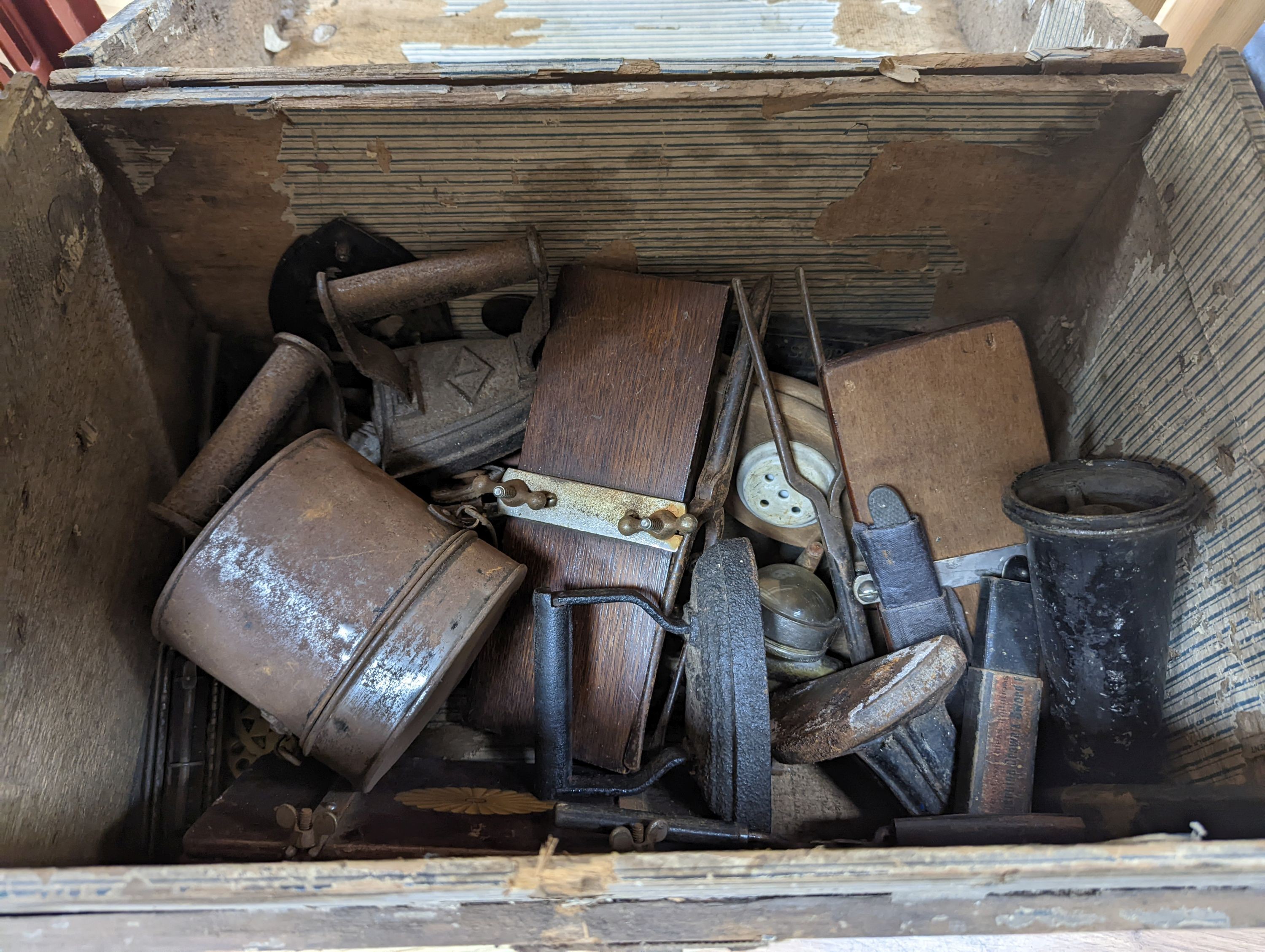 A domed trunk containing flat irons, elm cash-tray etc